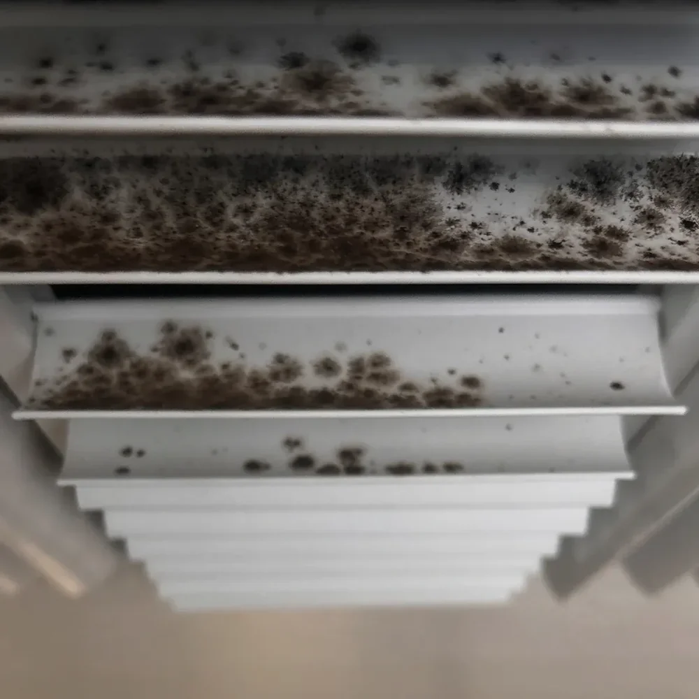 Ceiling vent grille showing buildup around the slots